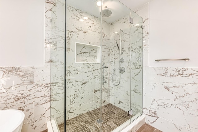 bathroom with tile walls and independent shower and bath