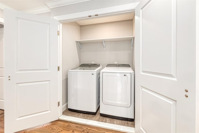 laundry room with washer and dryer, light hardwood / wood-style floors, and ornamental molding