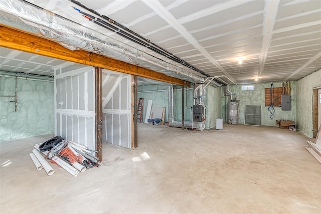 basement with heating unit, electric panel, and water heater