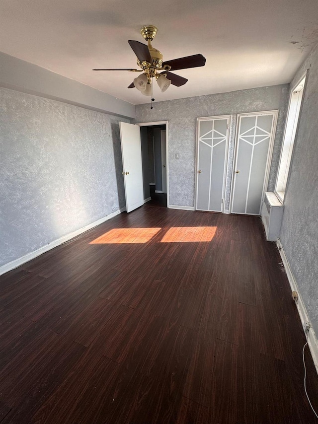 unfurnished bedroom with dark hardwood / wood-style floors and ceiling fan