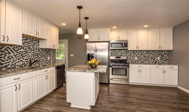 kitchen with a kitchen island, stainless steel appliances, hanging light fixtures, and dark wood-type flooring