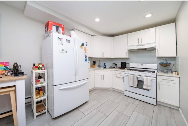 kitchen with tasteful backsplash, white cabinetry, sink, and white appliances