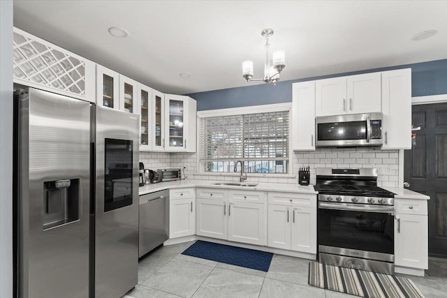 kitchen with white cabinetry, sink, hanging light fixtures, and appliances with stainless steel finishes