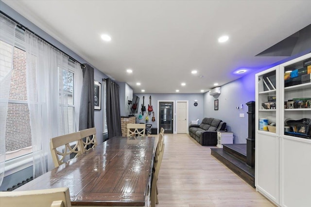 dining room with light wood-type flooring and a wall mounted AC