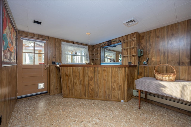 interior space with a baseboard radiator and wooden walls