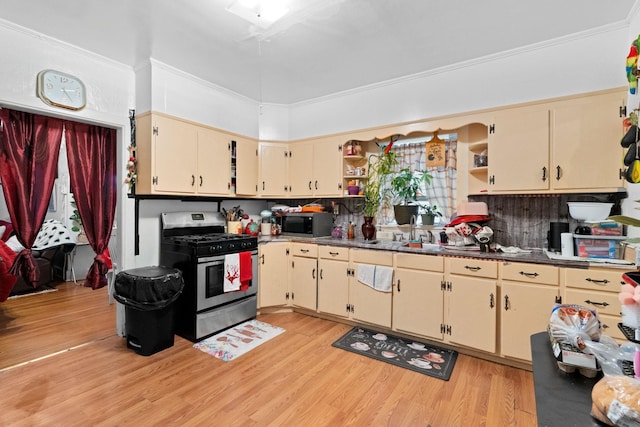 kitchen with sink, stainless steel appliances, light hardwood / wood-style flooring, crown molding, and cream cabinets