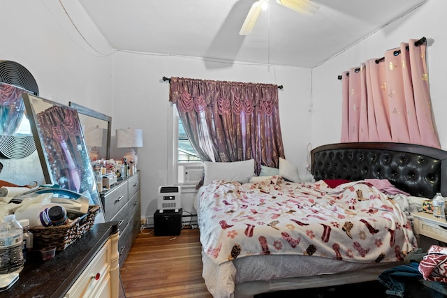 bedroom with hardwood / wood-style flooring, ceiling fan, and cooling unit