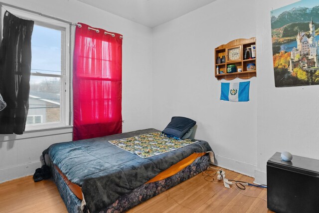 bedroom with multiple windows and hardwood / wood-style flooring