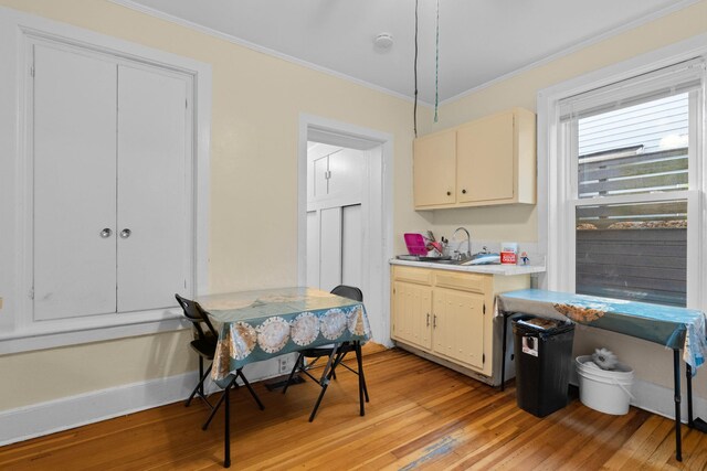 kitchen featuring ornamental molding, cream cabinets, and light hardwood / wood-style flooring