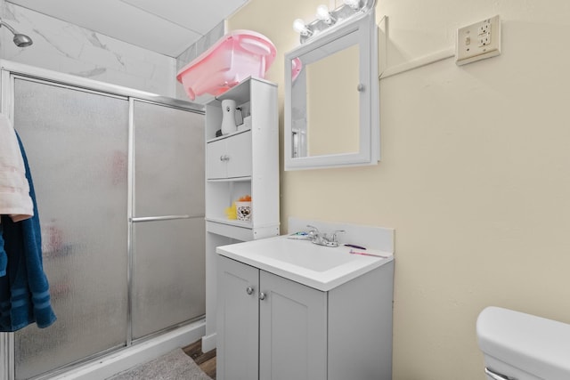 bathroom with vanity, toilet, and a shower with shower door