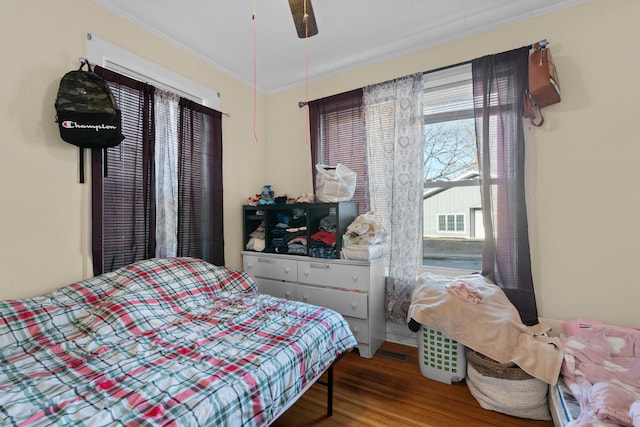 bedroom featuring ceiling fan, wood-type flooring, and ornamental molding