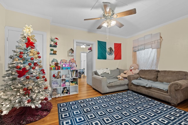 living room featuring hardwood / wood-style floors, ceiling fan, and crown molding