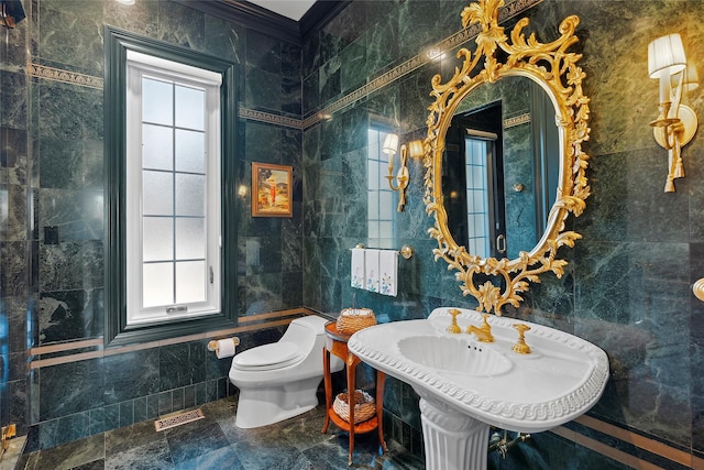 bathroom featuring toilet, tile walls, and ornamental molding