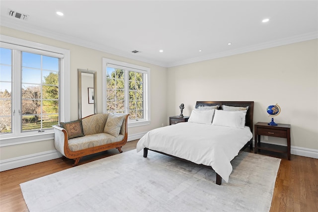 bedroom featuring wood-type flooring and ornamental molding