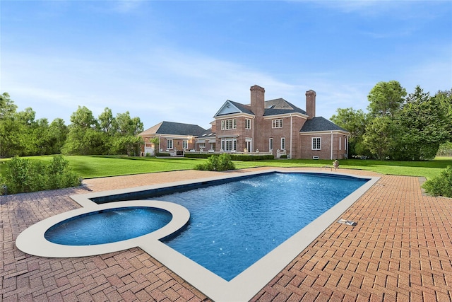 view of swimming pool with a lawn and an in ground hot tub