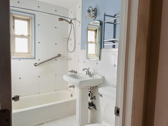 full bathroom featuring plenty of natural light, toilet, tile walls, and tiled shower / bath