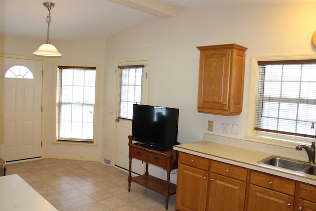 kitchen with lofted ceiling with beams, decorative light fixtures, a wealth of natural light, and sink