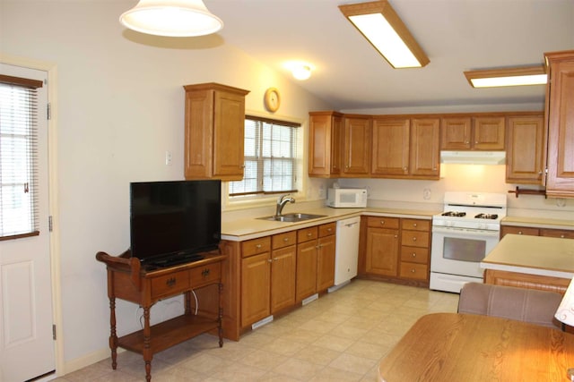 kitchen with lofted ceiling, white appliances, a healthy amount of sunlight, and sink