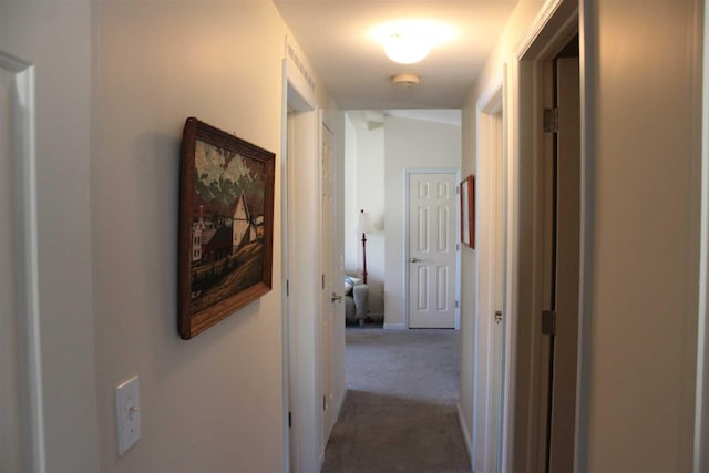 corridor with carpet flooring and lofted ceiling