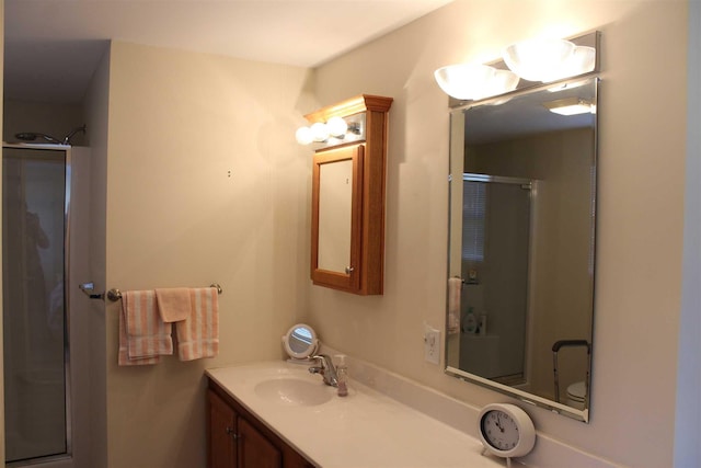 bathroom with vanity, toilet, and a shower with door