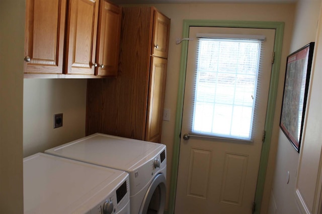 clothes washing area featuring cabinets and washer and dryer