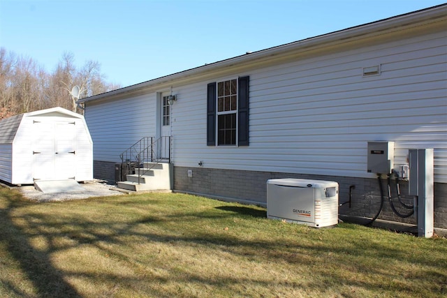 rear view of property with a yard and a storage unit