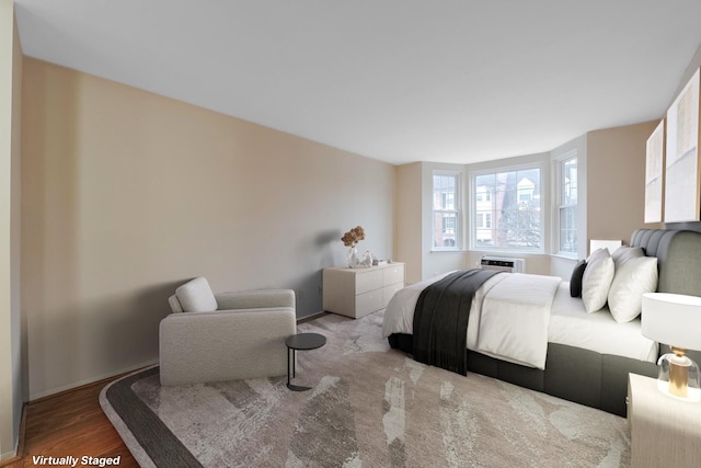 bedroom with wood-type flooring and a wall mounted AC