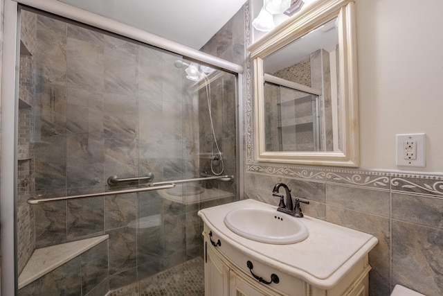 bathroom featuring vanity, tile walls, and a shower with shower door