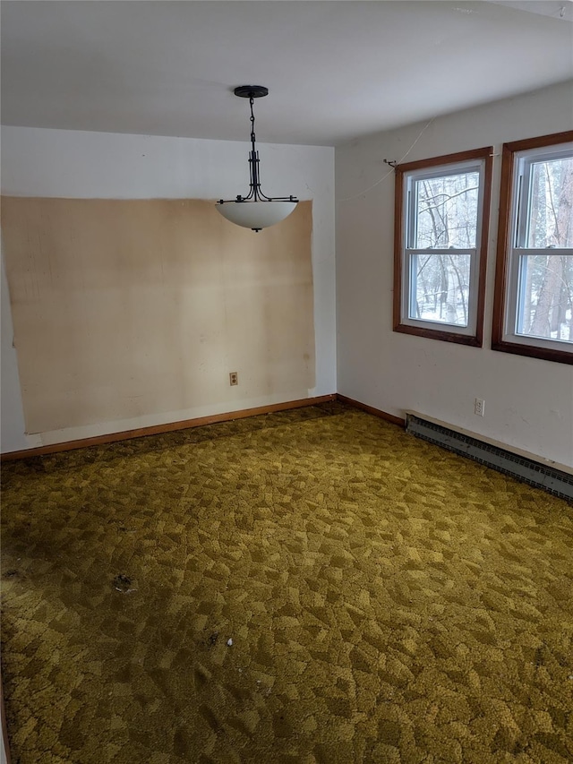 unfurnished dining area featuring dark carpet and baseboard heating