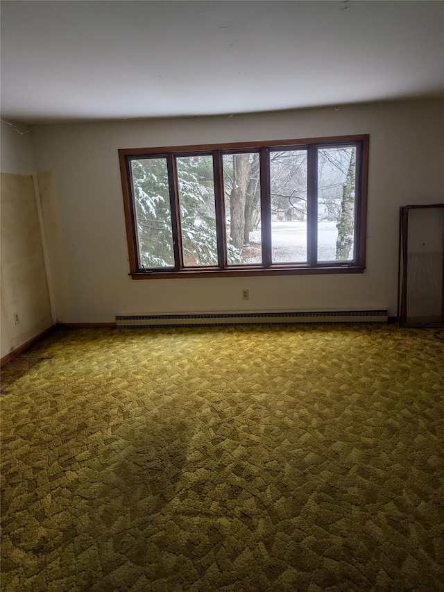 empty room featuring dark colored carpet and baseboard heating