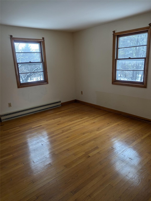 empty room featuring light hardwood / wood-style flooring and a baseboard heating unit