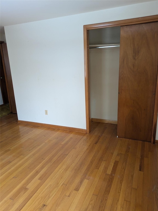 unfurnished bedroom with a closet and light hardwood / wood-style flooring