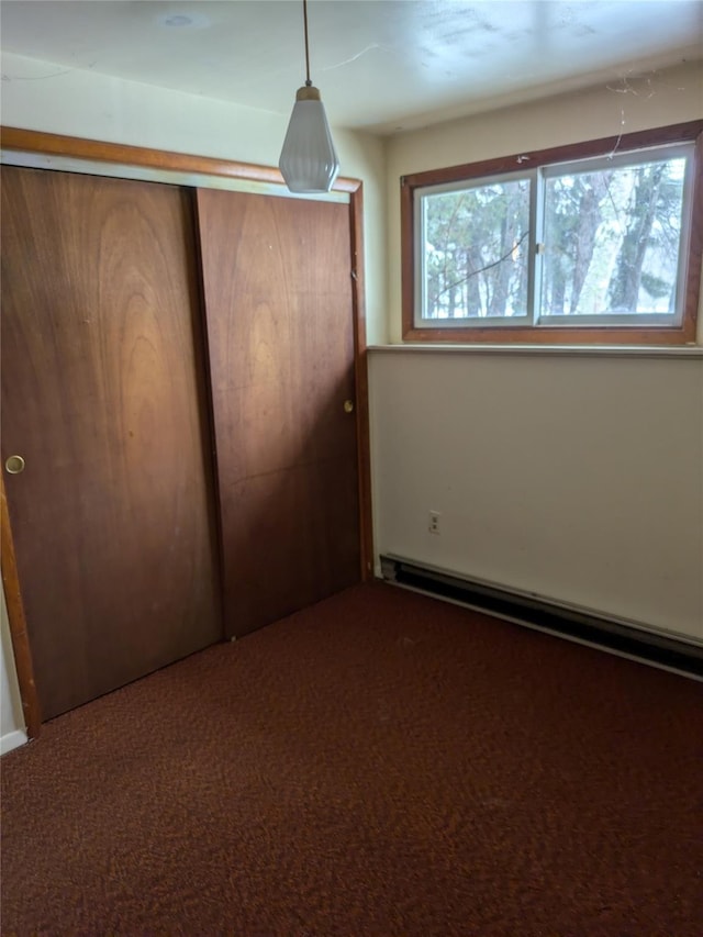 unfurnished bedroom featuring carpet floors and baseboard heating