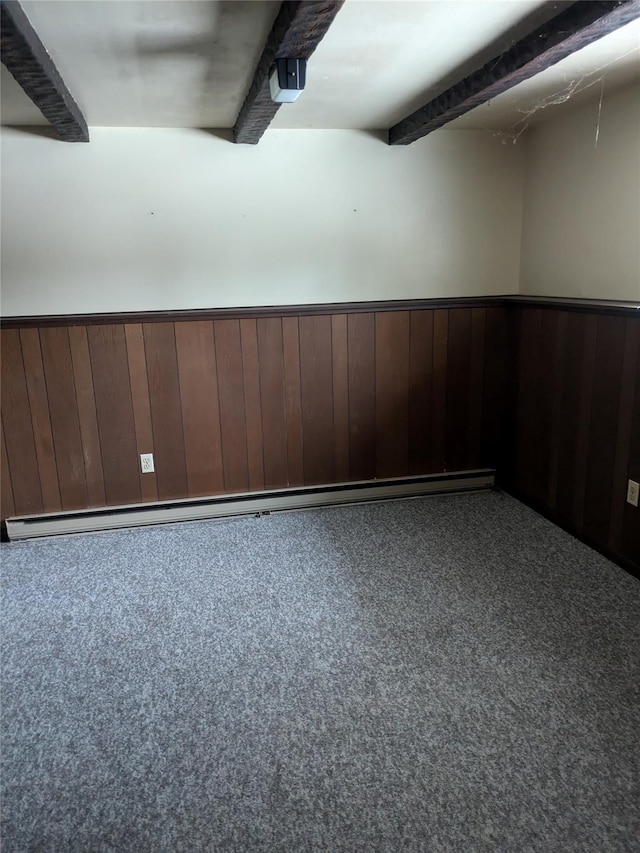 carpeted empty room featuring wooden walls