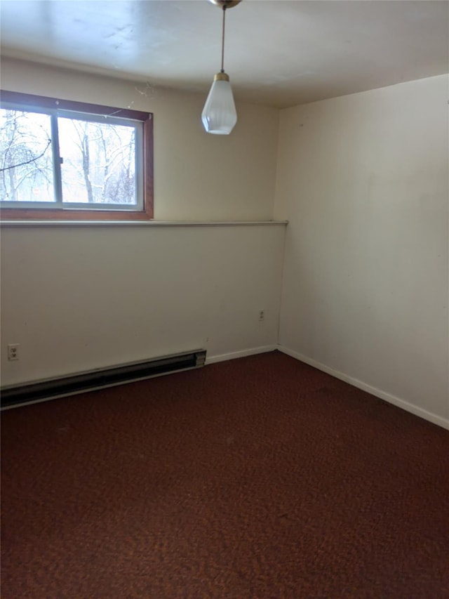 spare room featuring carpet and a baseboard heating unit