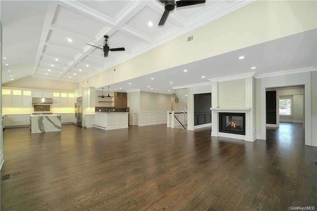 unfurnished living room with dark wood-style floors, coffered ceiling, ceiling fan, and a towering ceiling