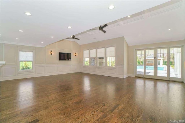 unfurnished living room with wood finished floors, vaulted ceiling, a ceiling fan, and a decorative wall