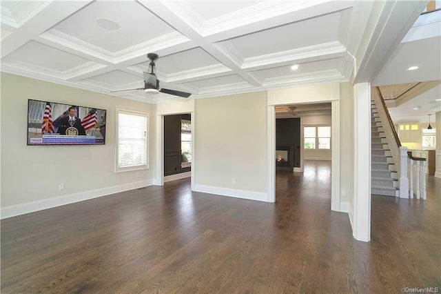 unfurnished living room featuring dark wood-style flooring, a ceiling fan, coffered ceiling, baseboards, and stairs