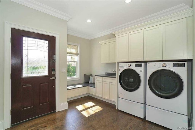 clothes washing area featuring ornamental molding, a sink, dark wood finished floors, cabinet space, and washing machine and clothes dryer