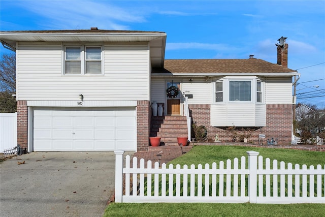 tri-level home featuring a garage and a front lawn