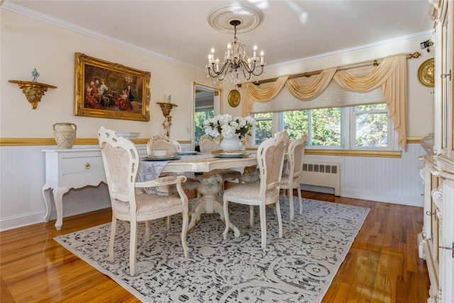 dining space featuring radiator, ornamental molding, dark wood-type flooring, and a notable chandelier