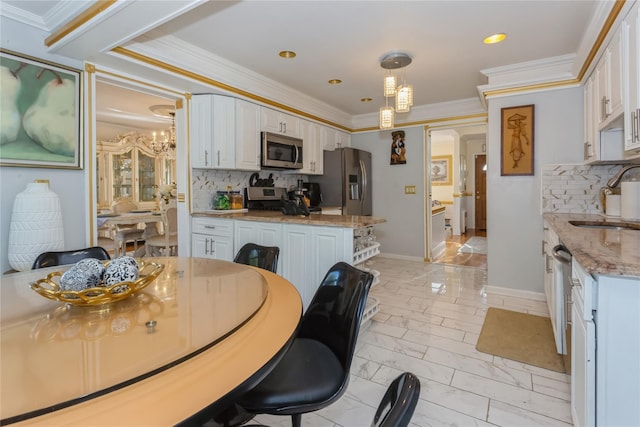 dining area with sink, a chandelier, and ornamental molding