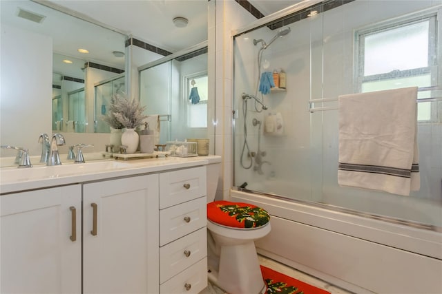 full bathroom with shower / bath combination with glass door, vanity, and toilet