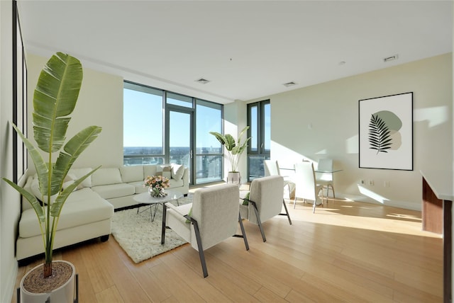 living room featuring light hardwood / wood-style floors and a wall of windows