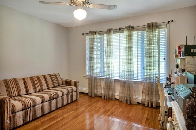 living room with ceiling fan, a wealth of natural light, and light hardwood / wood-style flooring