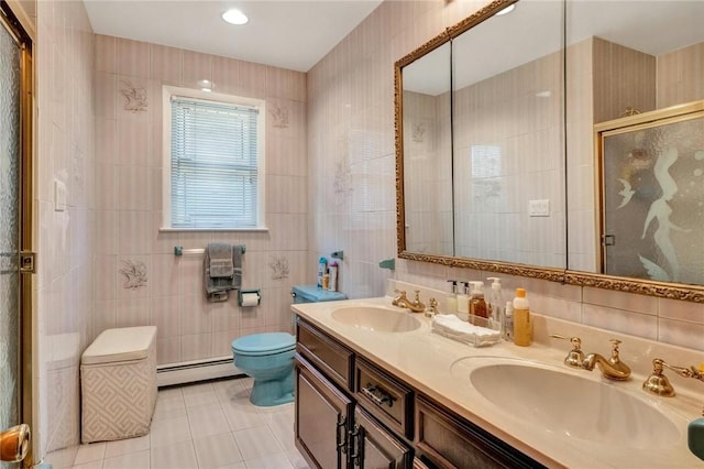 bathroom with baseboard heating, tile patterned flooring, a shower with door, vanity, and tile walls