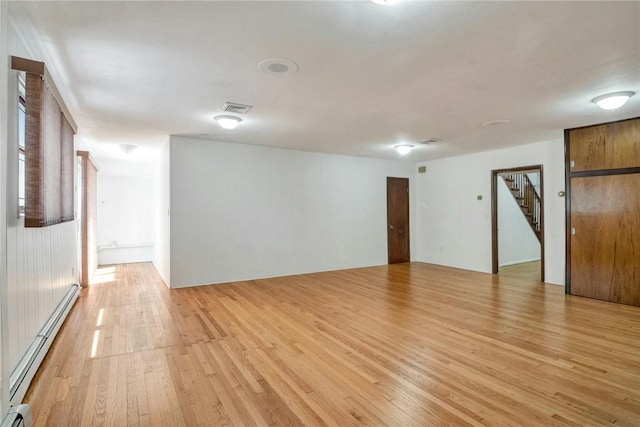 spare room featuring light hardwood / wood-style floors and a baseboard heating unit