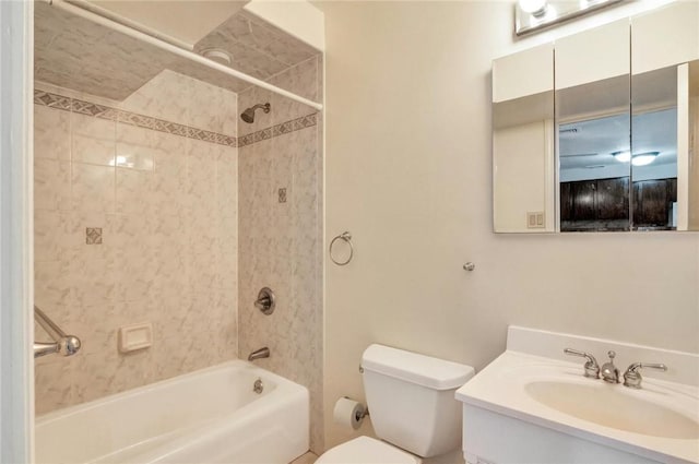 full bathroom featuring vanity, tiled shower / bath combo, and toilet