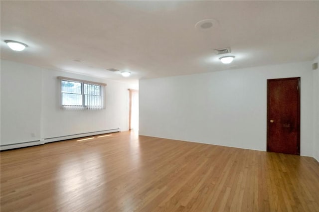 interior space featuring a baseboard heating unit and light wood-type flooring