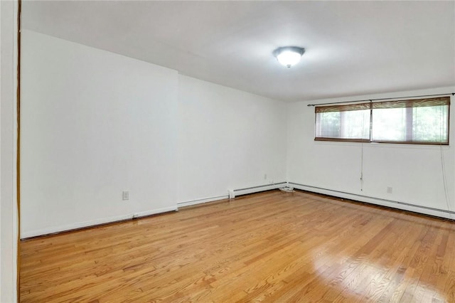 spare room featuring light wood-type flooring and a baseboard radiator